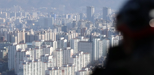 한 시민이 서울 남산에서 강북 아파트 밀집 지역을 바라보고 있다. <연합뉴스>